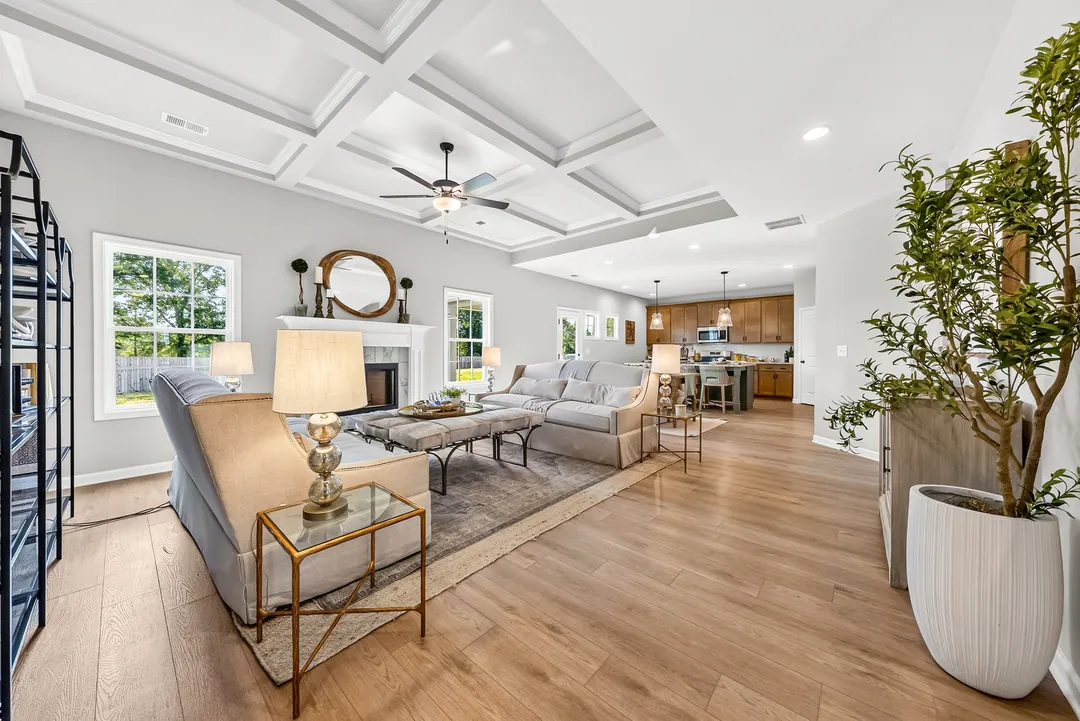 Open living room with a coffered ceiling that flows into the kitchen